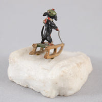 Sculpture miniature antique autrichienne en bronze représentant un teckel faisant du traîneau dans la neige.